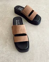 Sandalias bajas color marrón claro, con plataforma negra y doble tira ancha de cuero con ajuste de velcro.