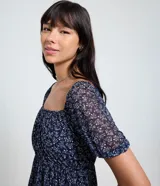 Vestido corto evasê de tule ligero color azul marino con estampado floral liberty fullprint en blanco. Posee escote recto, mangas cortas abullonadas y canesú fruncido en el busto.