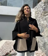 Saco tejido de punto en color negro, con corte holgado y mangas tres cuartos. Presenta bolsillos frontales amplios confeccionados en cuero metalizado color plateado y cierre frontal con botones.