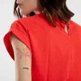 Blusa roja con textura de lunares, cuello redondo y mangas cortas con dobladillo.