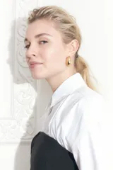 Aros colgantes dorados con forma de gota.