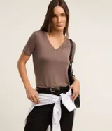 Blusa básica de manga corta con cuello en V, confeccionada en tejido de viscosa con elastano. Presenta un diseño liso y corte ajustado.