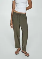 Pantalon de corte recto y estilo jogger, confeccionado en tejido fluido color verde militar. Presenta cintura elástica con cordón ajustable y bolsillos laterales.