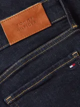 Pantalón de jean azul oscuro, corte skinny, tiro alto y largo hasta el tobillo.