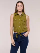 Camisa sin mangas de rayón texturado color blanco, de corte crop con cierre frontal de botones y lazos para anudar en el frente. Cuenta con cuello camisero, detalles de brillos en los hombros y bolsillos plaqué con solapa en el pecho.