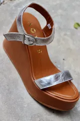 Sandalias de cuero color marrón chocolate con plataforma y taco corrido. Tira ancha sobre los dedos y tira al tobillo con hebilla dorada.