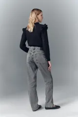 Jean de tiro alto confeccionado en denim rígido de color gris con lavado localizado. Presenta un corte de pierna recta y un detalle de apliques brillantes a lo largo de las costuras laterales.