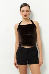 Top negro de terciopelo con escote halter, sin mangas y espalda descubierta.