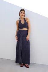 Falda larga de tejido brillante color azul con detalle de nudo en la cintura.