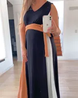 Vestido largo de corte imperio, con paneles verticales en color negro, blanco y ocre. Incluye lazo de tela ocre para ajustar debajo del busto.