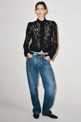 Blazer de encaje negro con hilatura de algodón, cuello redondo, manga larga y cierre frontal de botones.