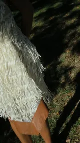 Vestido minifalda con cuello halter, confeccionado en tela de flecos y lentejuelas, con espalda al aire.