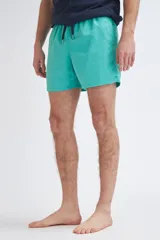 Short de baño liso en color verde, con corte recto y elástico en la cintura.