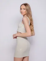 Falda corta negra de tela brillante con textura acanalada y elástico en la cintura.