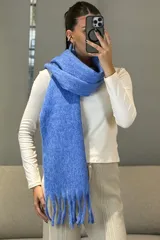 Bufanda de tejido grueso y suave, color blanco, con diseño de flecos en los extremos.