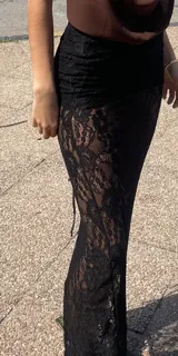 Falda larga blanca de encaje con abertura lateral y cintura elástica.