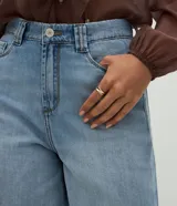 Bermuda estilo jorts de cintura alta, confeccionada en denim de algodón con lavado clásico, trabillas para cinturón, cierre frontal con botones y bolsillos funcionales.