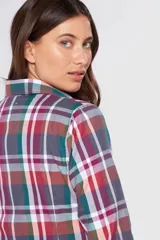 Camisa a cuadros de manga larga con cierre frontal de botones, cuello camisero y un bolsillo aplicado en el pecho.
