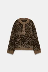 Jersey de punto con textura suave, cuello redondo y manga larga. Presenta un estampado animal print en tonos marrones y cierre frontal con botones.