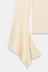 Camiseta de cuello redondo y manga larga, confeccionada en tejido rib con mezcla de lyocell. Presenta un diseño ajustado con terminación de volantes en los puños y bajo recto.