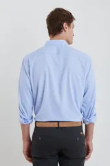 Camisa celeste de vestir, de manga larga, con cuello clásico y bolsillo en el pecho.