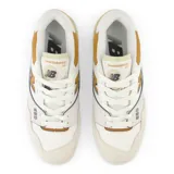 Championes urbanos New Balance modelo BBW550ST, color blanco con detalles en beige y mostaza, confeccionados en cuero sintético, con logo "N" característico en los laterales y suela de goma.