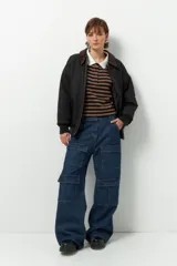 Pantalón cargo ancho de jean, color azul oscuro, con tiro bajo y ocho bolsillos.