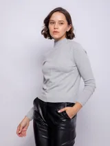 Polera gris de tejido de punto, manga larga y cuello alto.