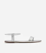 Sandalias planas blancas con tira elástica en el tobillo y tira fija sobre los dedos.