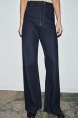 Jeans de tiro alto estilo wide leg, color marrón oscuro, con diseño de cinco bolsillos y cierre frontal de cremallera y botón metálico.