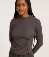 Blusa gris oscuro texturizada de poliéster y elastano, con cuello alto, mangas largas y detalle de fruncido lateral.