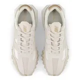 Championes New Balance modelo XC72, color beige y blanco, con detalles en marrón claro.