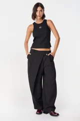 Pantalon de corte amplio y tiro alto con diseño cruzado en la cintura y cierre frontal con boton. Presenta una silueta fluida y relajada.