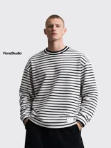 Buzo de tela fina, liviano y cómodo, con estampado de rayas horizontales blancas y negras, cuello redondo y puños acanalados.