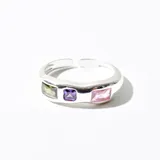 Anillo plateado con tres piedras cuadradas de color verde, violeta y rosa.