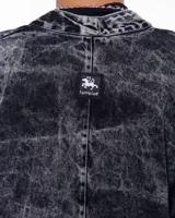 Kimono negro con efecto lavado, confeccionado en algodón. Tiene corte amplio, mangas 3/4, bolsillos laterales y cierre frontal con hebilla metálica.