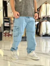 Pantalón cargo de jean azul con múltiples bolsillos en los laterales y diseño holgado.
