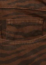 Pantalón de jean con diseño recto y tiro alto, confeccionado en algodón con estampado animal print de cebra en tonos marrones. Cuenta con cierre frontal de cremallera y botón, trabillas para cinturón y cinco bolsillos clásicos.