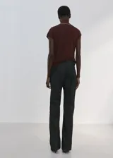 Top marrón sin mangas, de corte recto y ajuste cómodo, con cuello alto y una bufanda o lazo integrado con bordes claros.