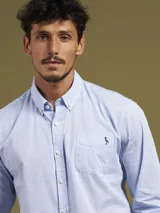 Camisa de vestir a rayas verticales azules y blancas, de corte regular fit y manga larga.