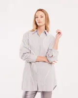 Camisa celeste de algodón con corte oversized, botones frontales a tono y vivos blancos ondulados en el frente.