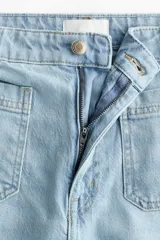 Jean de denim celeste de tiro alto con piernas amplias, bolsillos delanteros de parche y raya marcada al frente y en la espalda.
