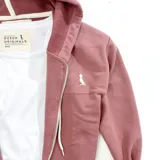Campera con capucha color rosa viejo, con cierre frontal y bolsillos tipo canguro.