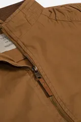 Campera color marrón confeccionada en gabardina suave, resistente y liviana. Diseño clásico con cuello medio y bolsillos laterales con cierre.