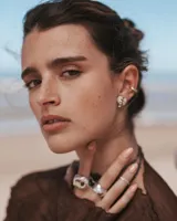 Anillo dorado con forma irregular y un agujero en el centro.