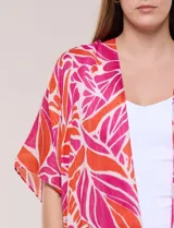 Kimono de gasa ligera color fucsia y naranja, con estampado de hojas, mangas cortas amplias, diseño abierto al frente y detalle de borlas en el ruedo asimétrico.