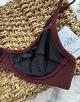 Top de bikini negro con borde bordeaux, con aro y breteles finos.