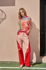 Musculosa de punto con cuello alto, sin mangas y estampado con motivos ecuestres en tonos naranja, celeste, amarillo y rosa.