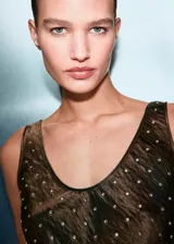 Top sin mangas de escote redondo, confeccionado en tejido satinado color bronce con apliques de cristales brillantes. Presenta un corte recto y ajuste entallado.