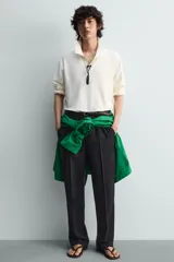 Sandalia tipo ojota o chancleta de goma, con base de color verde oscuro y tiras negras. Presenta una suela plana.